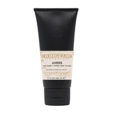 Black tube of amber hand cream on a white background