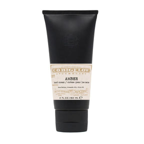 Black tube of amber hand cream on a white background