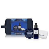 Murdock Gentleman Shave Set including a navy blue zippered travel pouch, shaving cream jar, dark blue pump bottle of Post Shave Balm, and a white microfiber towel, arranged on a white background.