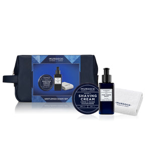 Murdock Gentleman Shave Set including a navy blue zippered travel pouch, shaving cream jar, dark blue pump bottle of Post Shave Balm, and a white microfiber towel, arranged on a white background.
