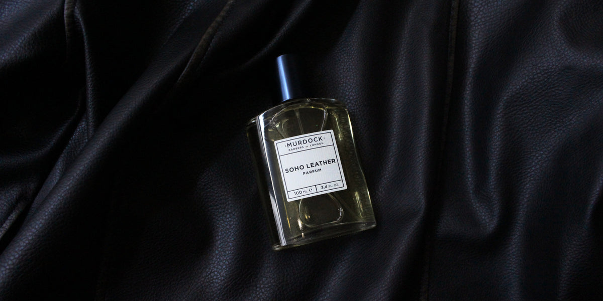 A bottle of Murdock London Soho Leather perfume placed on a draped black leather surface.
